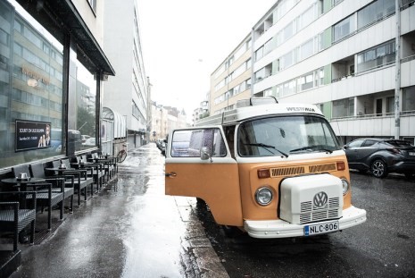Photo of a Volkswagen Westfalia van parked on a city street with an open door.