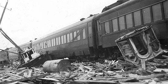 Photo en noir et blanc d'un train déraillé.