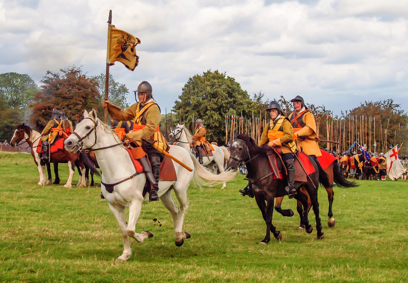 Photo d'un groupe de reconstitution de la guerre civile anglaise. Une groupe de cavalières est au premier plan, vétues d'armures d'époque. A l'arrière-plan on peut voir un carré de piquiers et une bannière